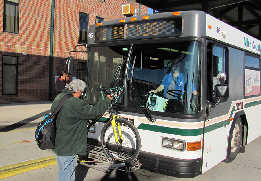 A man places a bike on the bike rack on the bus of the RTA. There are bike racks on all buses. If you need to ride the bus with a bike, read our bike policy.